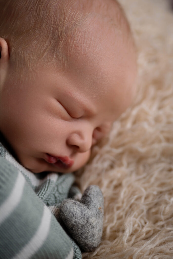 Close-up of newborn baby in natural position, minimalist and safe newborn photography New Richmond WI.