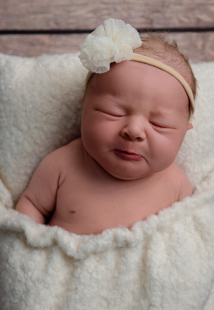 Mother kissing newborn baby during cozy lifestyle newborn session in western Wisconsin