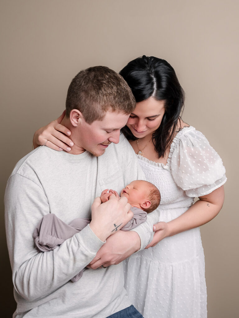 Newborn baby girl swaddled in purple wrap with delicate details photographed in New Richmond Wisconsin studio