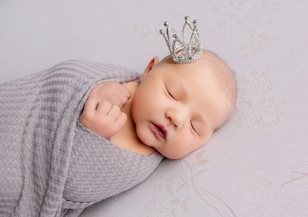 Wrapped studio newborn photography of a baby girl.