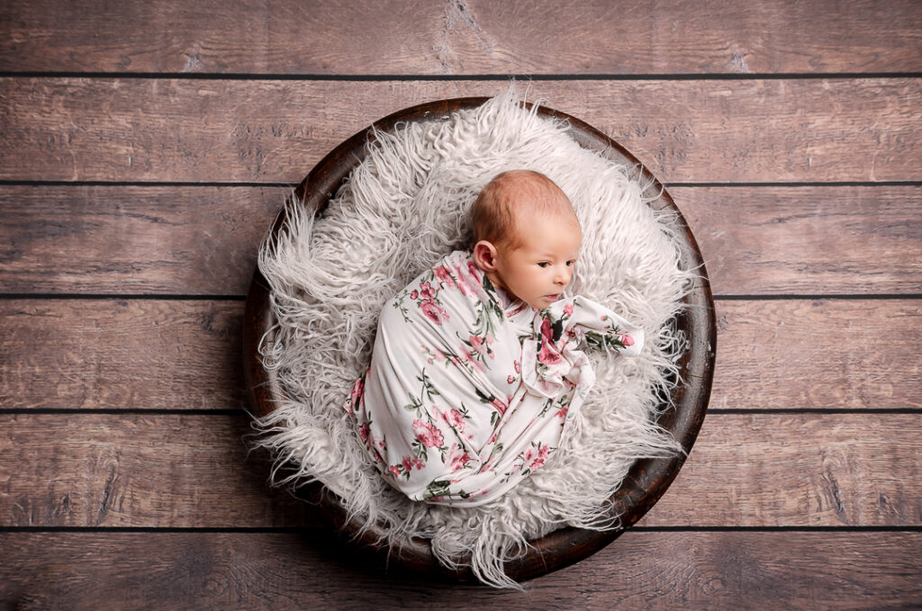 Newborn baby wrapped in soft neutral blanket during posed studio session in New Richmond WI by Alabaster Photos