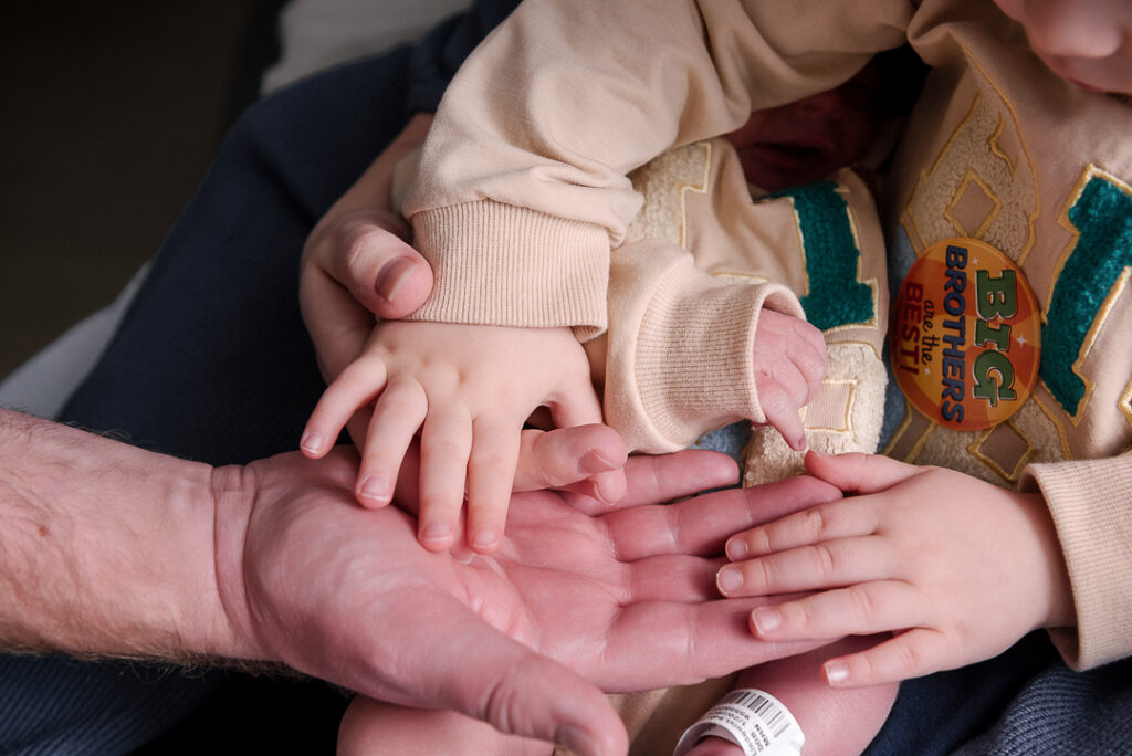 Gentle parent and newborn interaction captured in minimalist studio, emotional newborn photography Wisconsin.